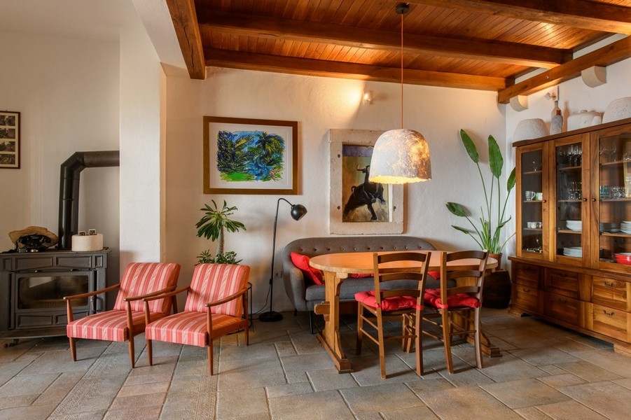 Vardagsrum med träbjälkar, öppen spis och sittgrupp