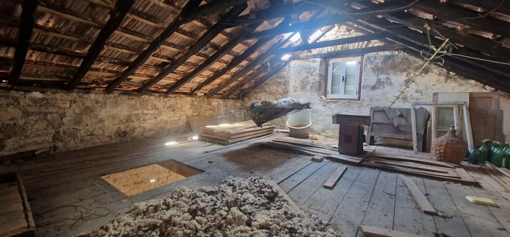 Gammalt stenhus på vinden med trätak