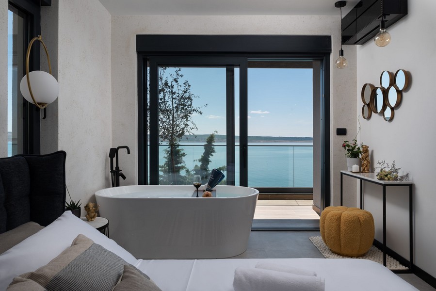 Badrum med badkar och panoramautsikt över havet