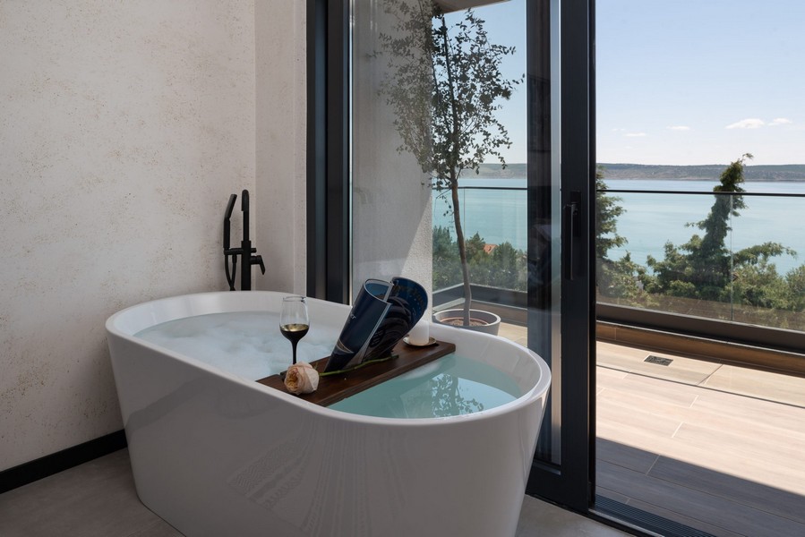 Fristående badkar vid fönstret med havsutsikt