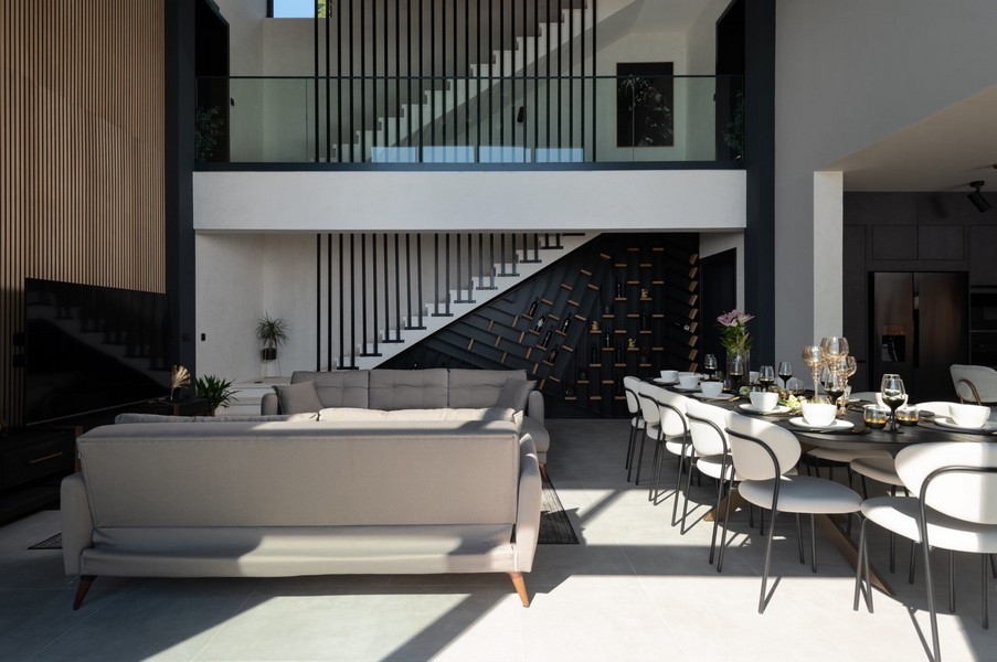 Elegant vardagsrum och matplats med galleri och trappor