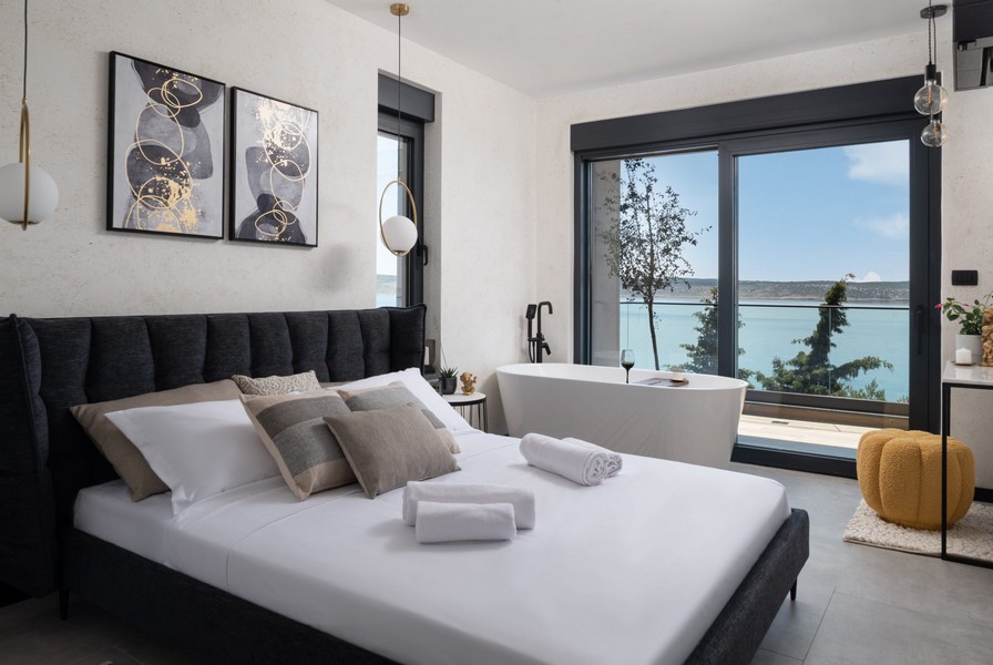 Sovrum med dubbelsäng, fristående badkar och havsutsikt