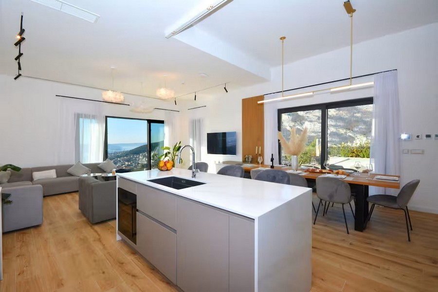 Öppet vardagsrum med kök, matplats och havsutsikt