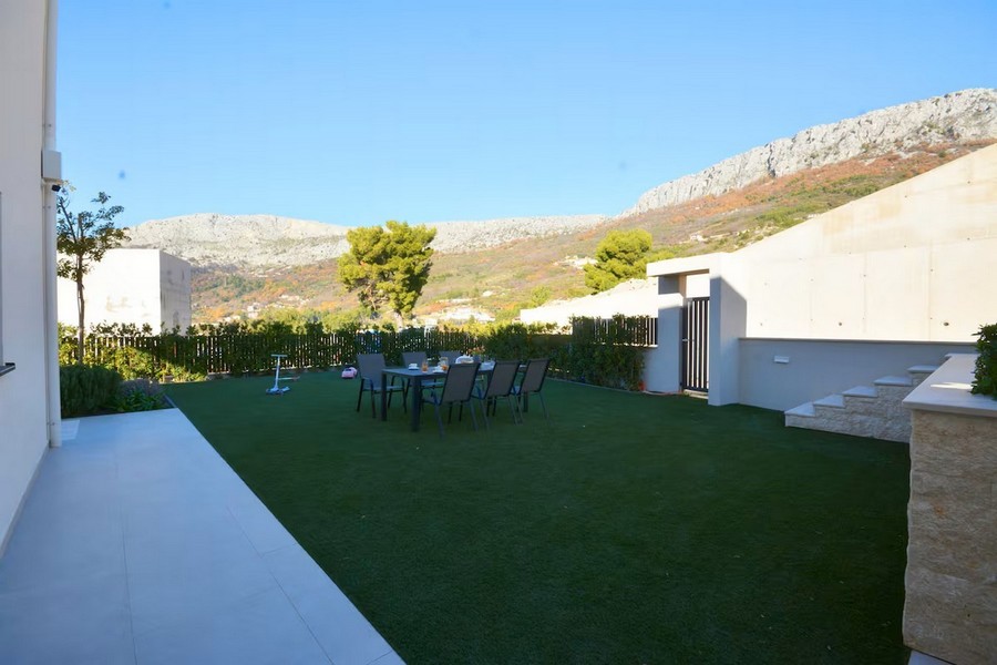 Modernt sommarkök med öppen spis och matbord