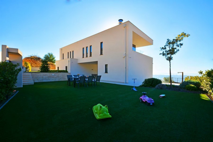 Trädgårdsområde med sittplatser bakom modern villa i Dalmatien