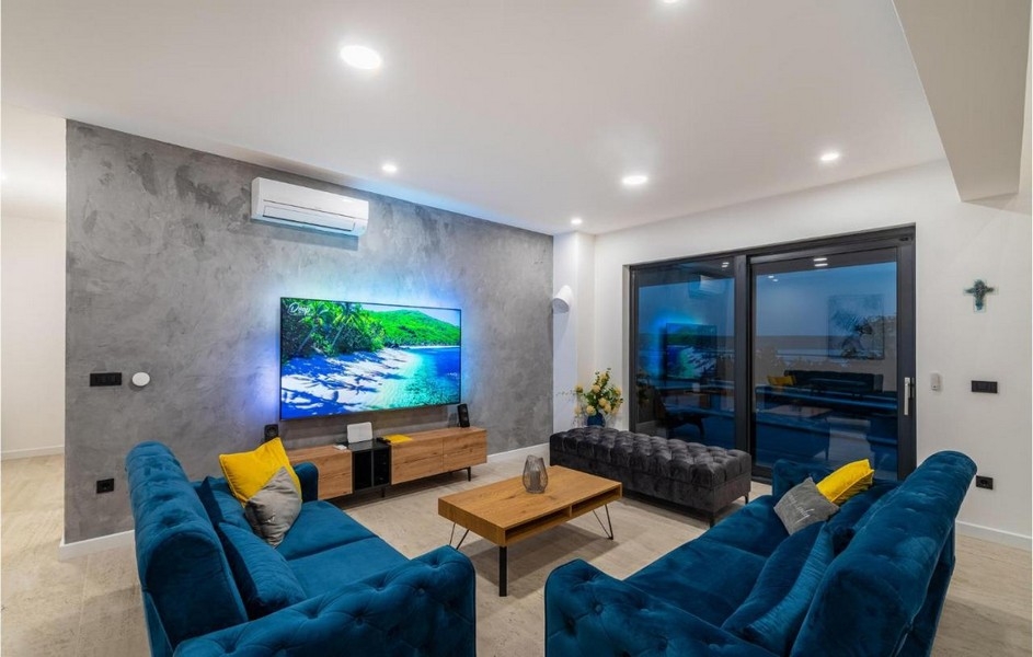 Vardagsrum med soffa och stor TV