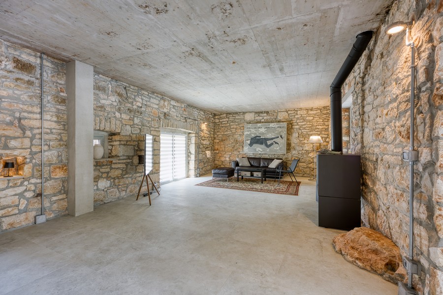 Rymligt vardagsrum med stenväggar och öppen spis