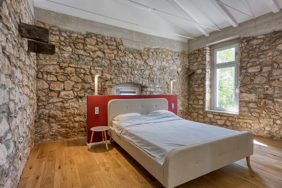 Sovrum med naturstensväggar och trägolv