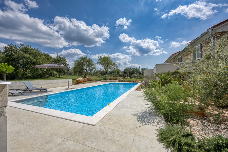 Pool med solterrass och solstolar - fastighet H3684