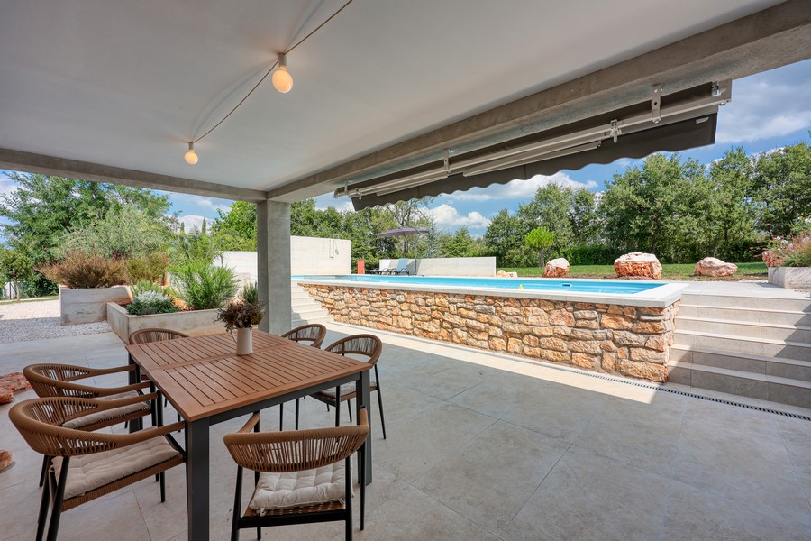 Täckt terrass med matplats vid poolen