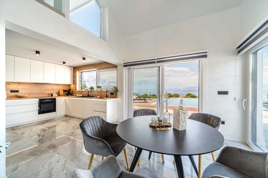 Matplats med utsikt över poolen och havet genom panoramafönster