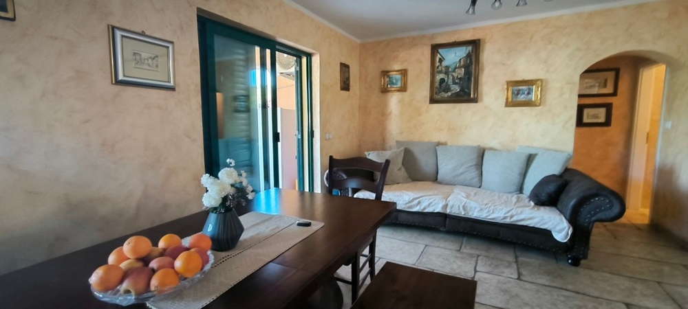 Vardagsrum med soffa, bord och tillgång till terrass