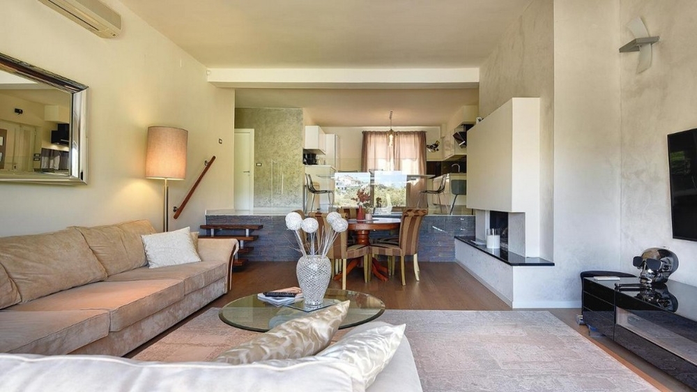 Ljust vardagsrum med soffa, öppen spis och intilliggande matplats