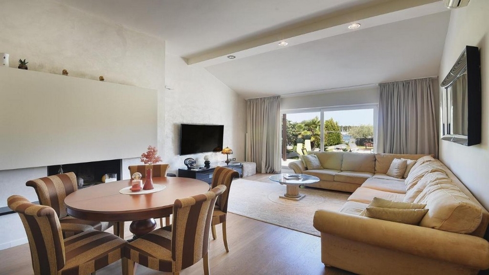 Vardagsrum med stort fönster fram och utsikt över trädgården