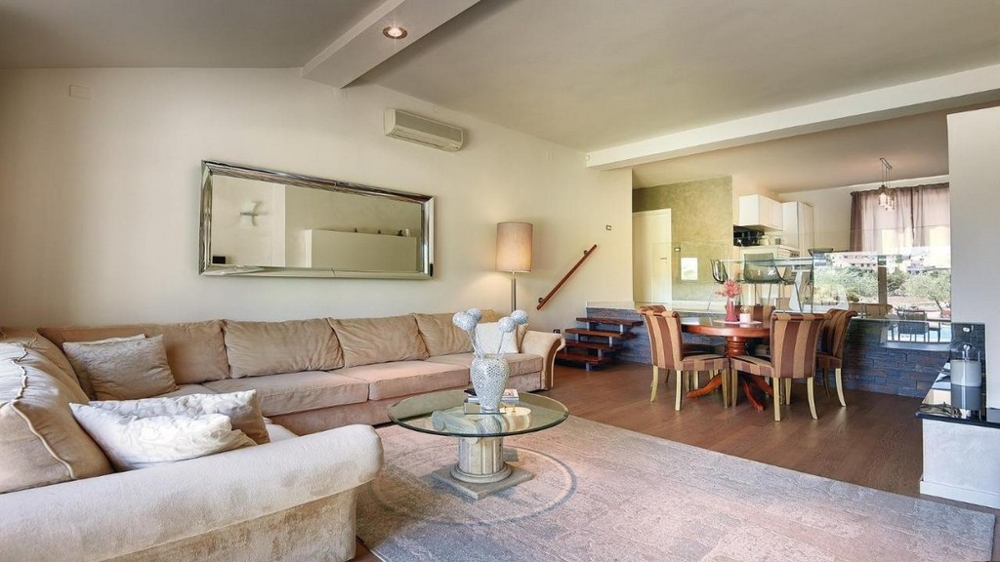 Mysigt vardagsrum med hörnsoffa, spegel och matplats