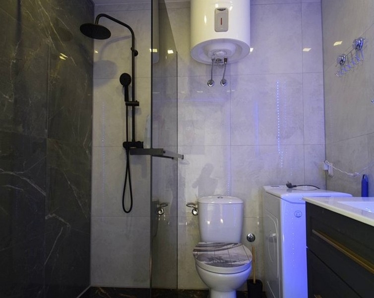 Modernt badrum med dusch och tvättmaskin