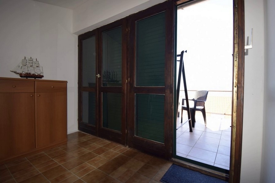 Tillgång till terrassen med havsutsikt genom stora glasdörrar