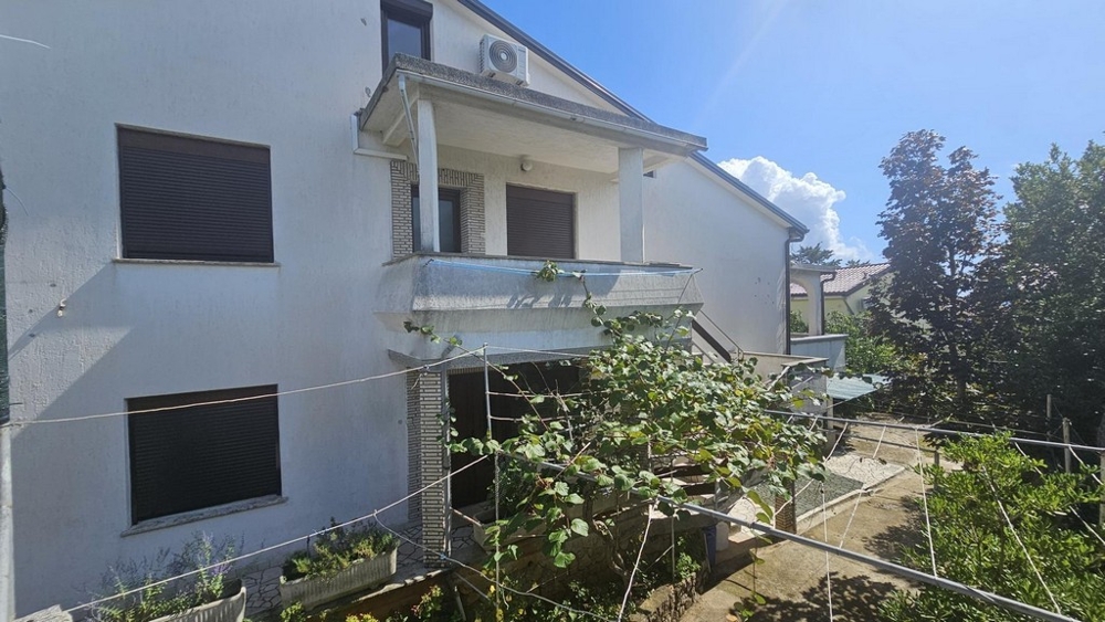 Exteriör vy av parhus med balkong och trädgård