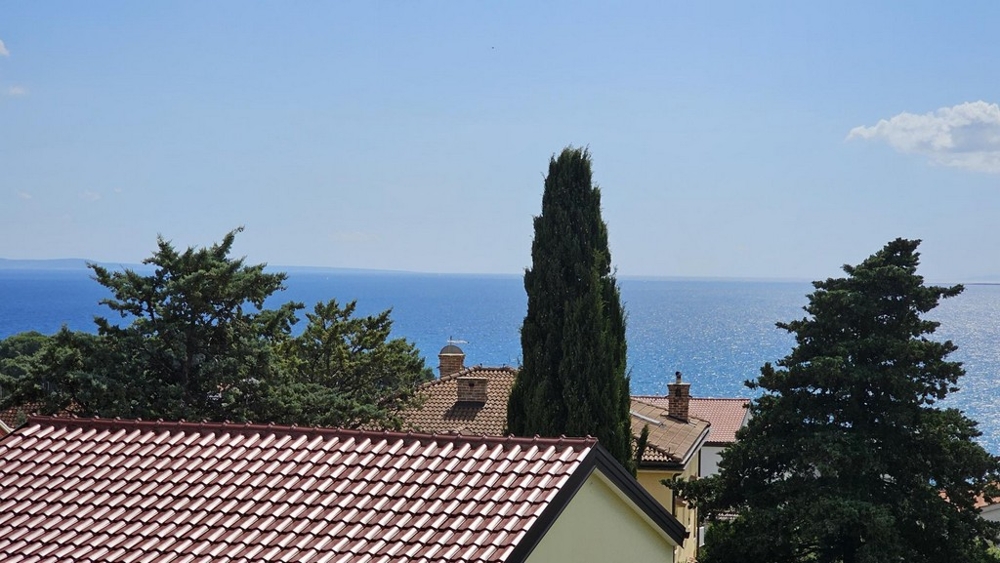 Havsutsikt från balkongen över tak och träd