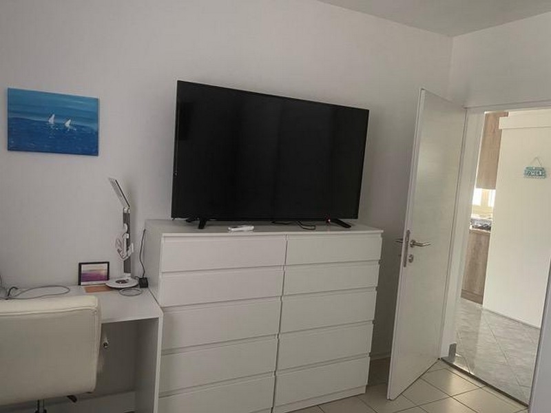 Sovrum med byrå och stor TV