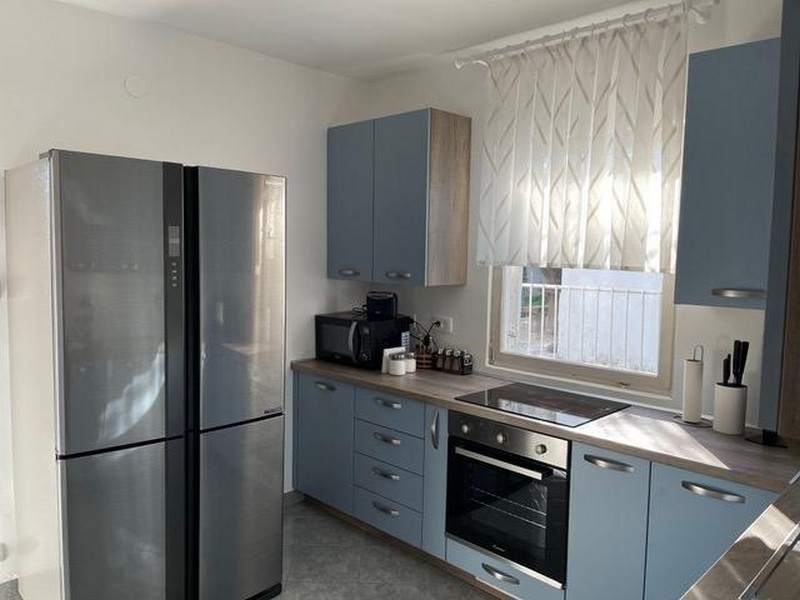 Modernt kök med inbyggda vitvaror och fönster