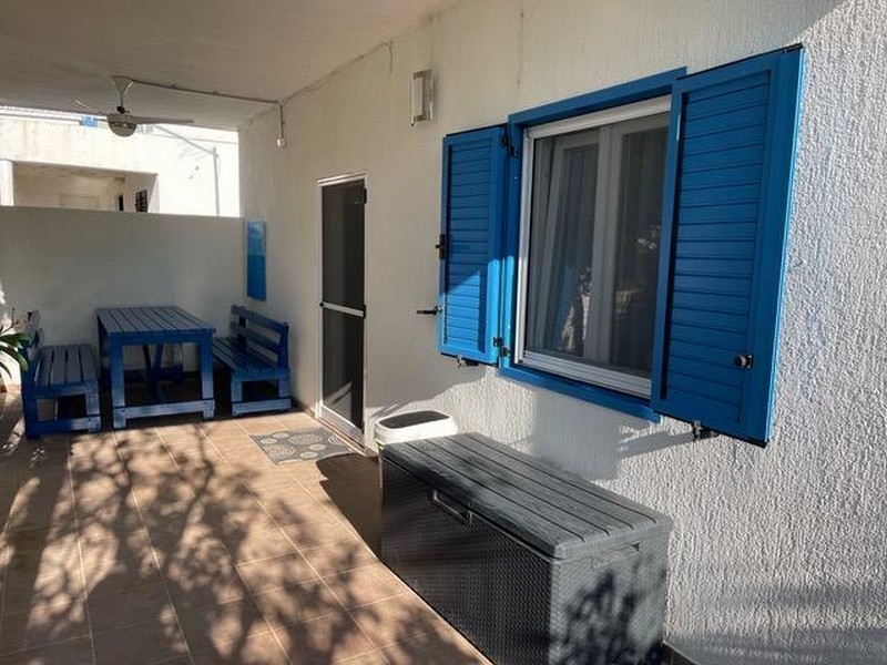 Täckt terrass med blå fönsterluckor