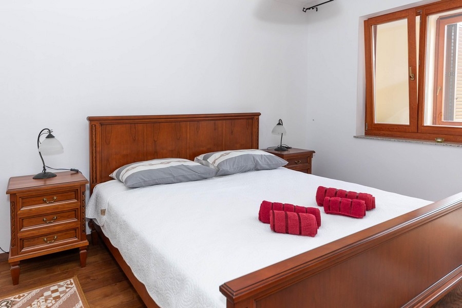 Sovrum med dubbelsäng och sängbord i trä