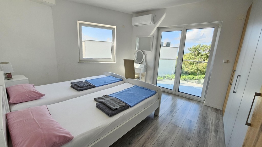 Sovrum med två bäddar och utgång till balkong