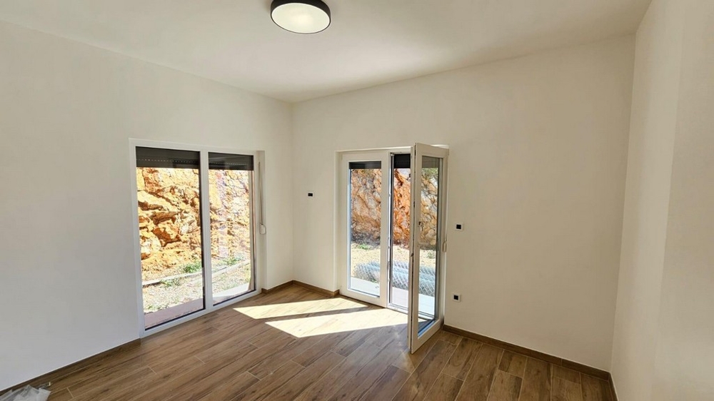 Sovrum med fönster från golv till tak och utsikt över klipporna