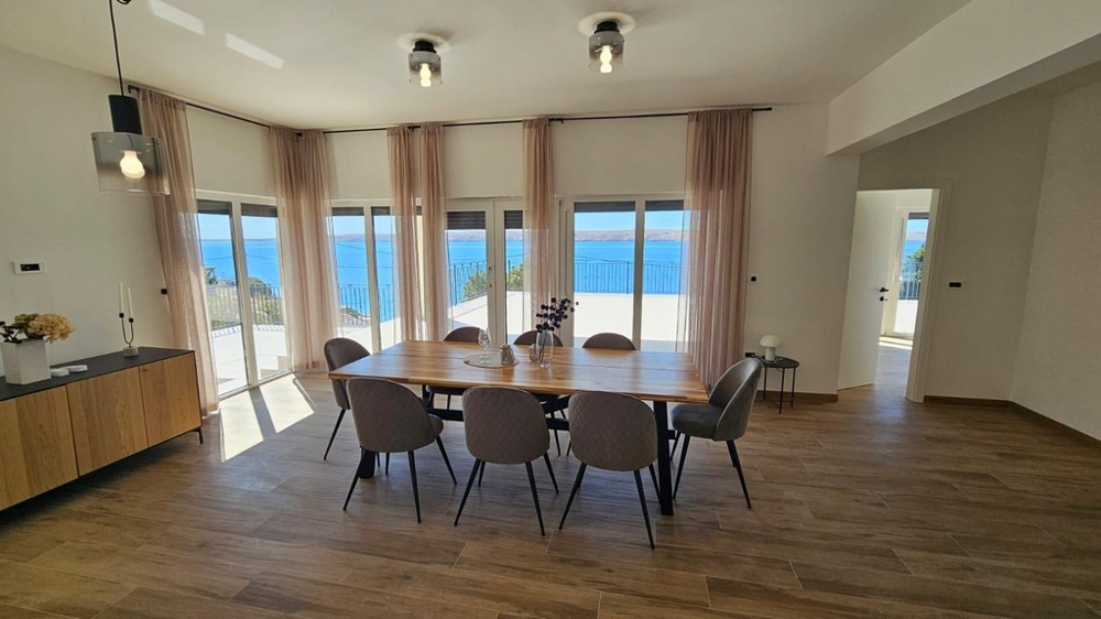 Ljust matsal med stort bord och havsutsikt