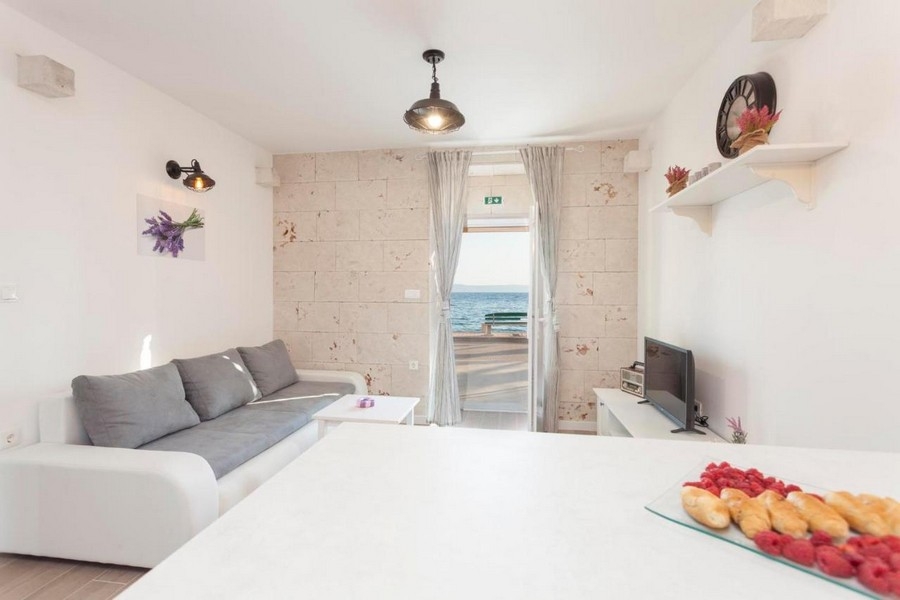 Ljust vardagsrum med soffa och havsutsikt