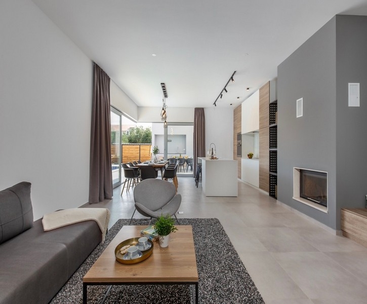 Ljust vardagsrum med öppen spis och utgång till terrassen