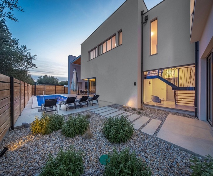 Villa med trädgård och pool på kvällen