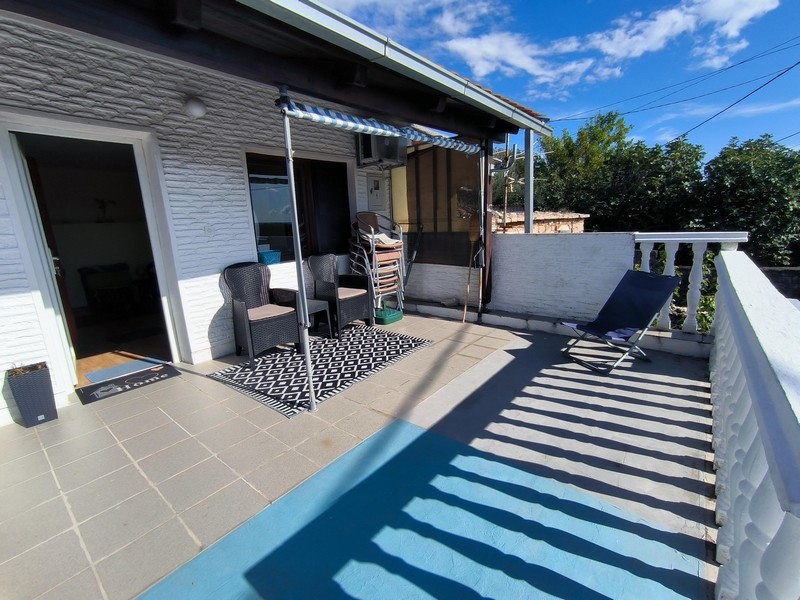 Solig terrass med sittgrupp och markis