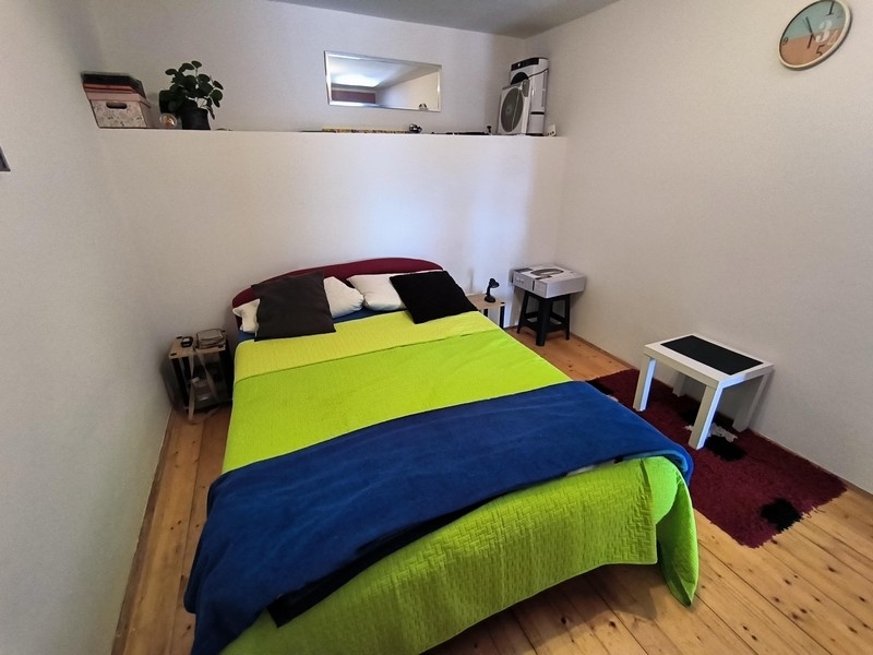 Sovrum med dubbelsäng och trägolv