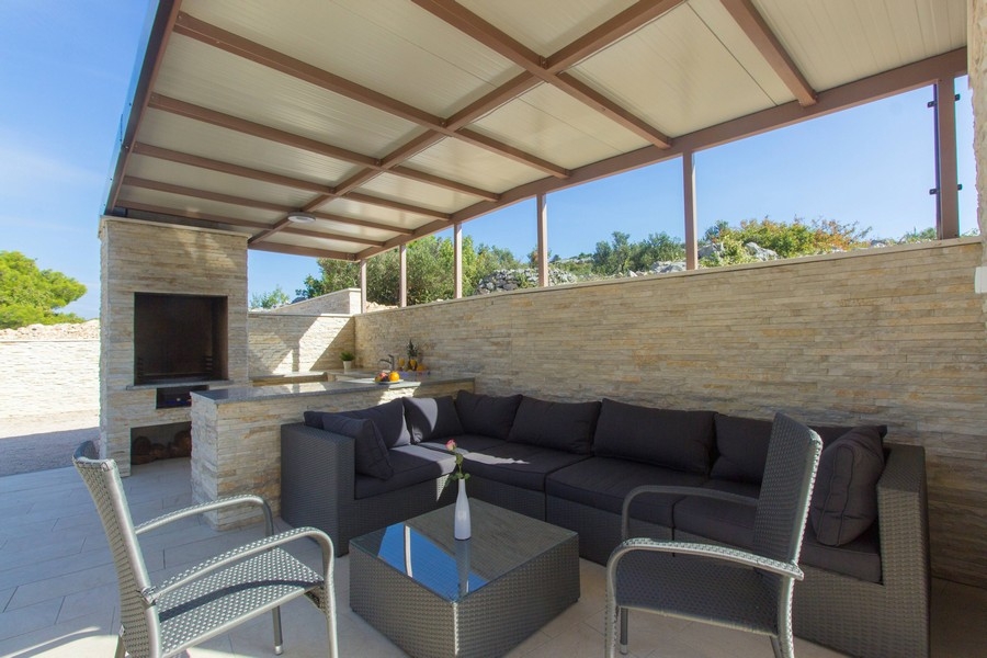 Täckt terrass med sittgrupp lounge och grill öppen spis