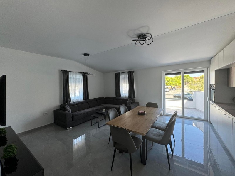 Modernt vardagsrum med utsikt över terrassen.