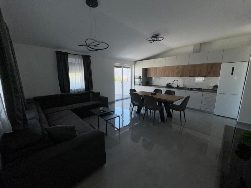 Modernt vardagsrum med öppet kök och matplats