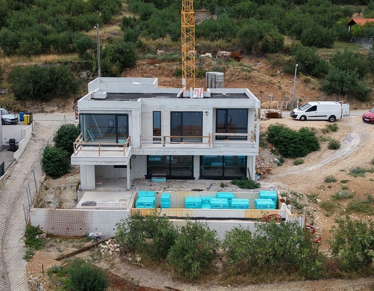 Ny villa med pool under uppbyggnad från luften