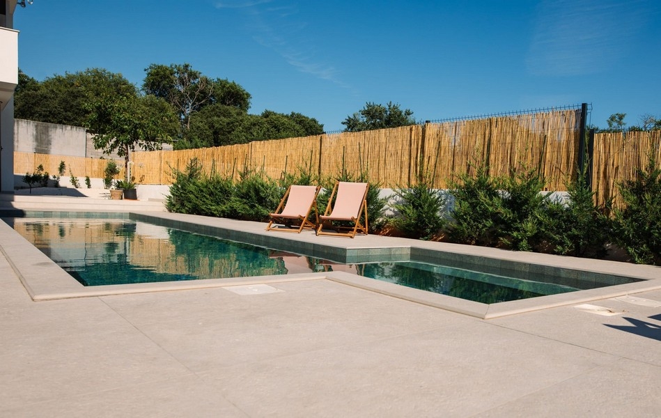 Medelhavspoolområde med solterrass och medelhavsväxter nära Sibenik.