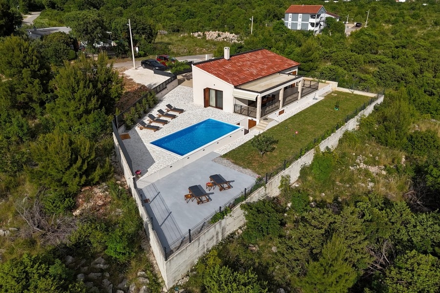 Flygfoto över fastigheten och poolen