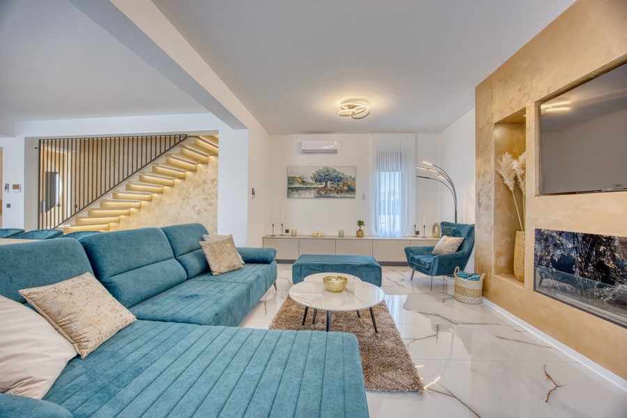 Vardagsrum och utsikt över de upplysta trappan.