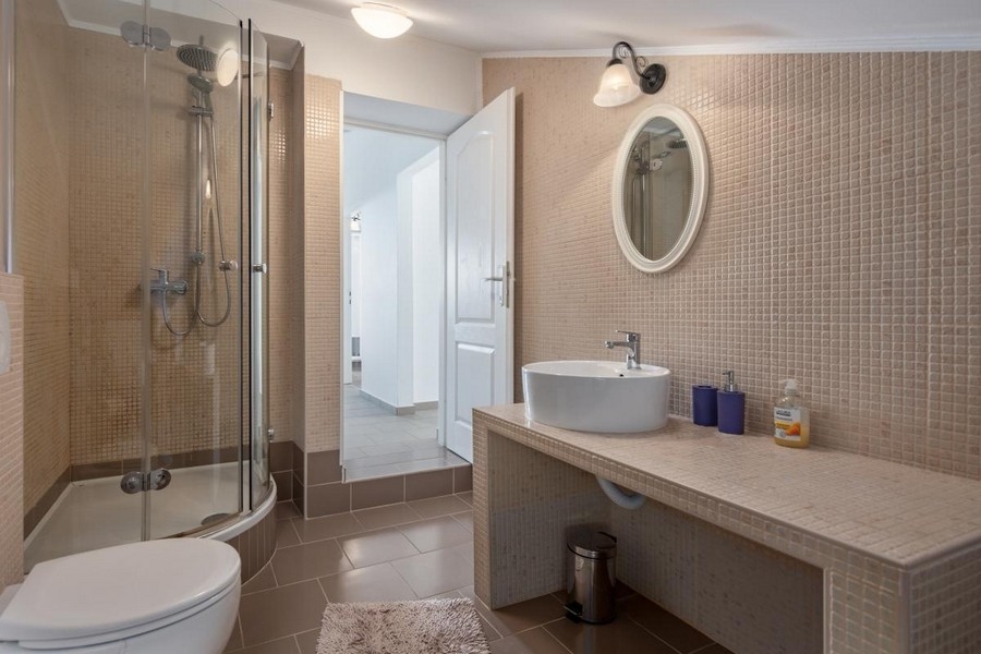 Badrum med rund dusch och tvättplats