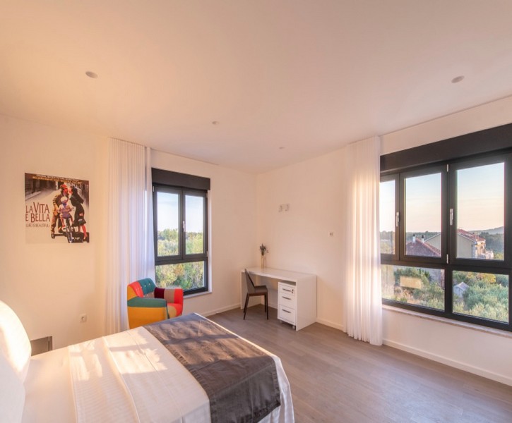 Sovrum med skrivbord och panoramafönster