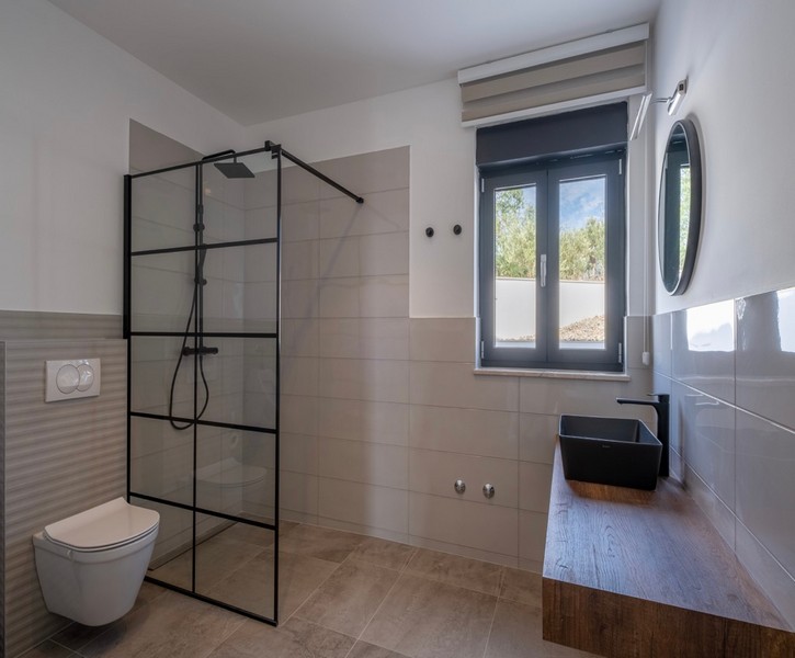 Modernt badrum med stor dusch och trähandfat