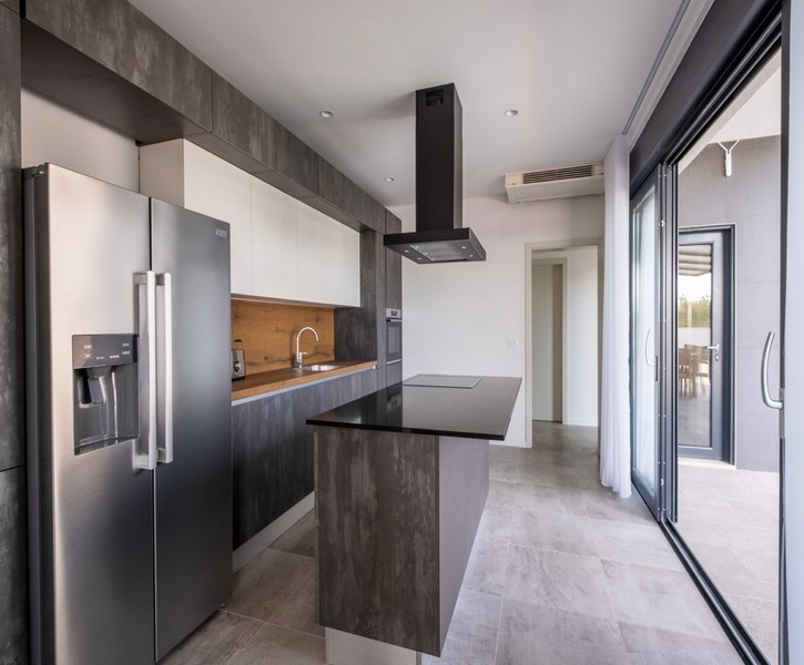 Modernt kök med kokö och tillgång till terrass