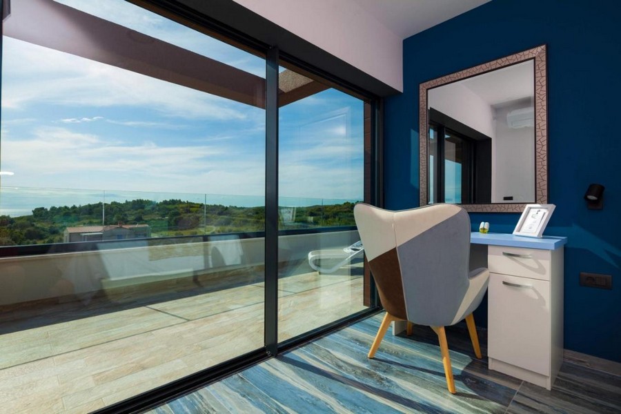 Sovrum med sminkbord och stor glasfront mot altan