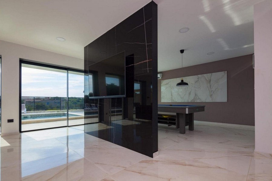 Öppen planlösning med moderna element och utsikt över poolen