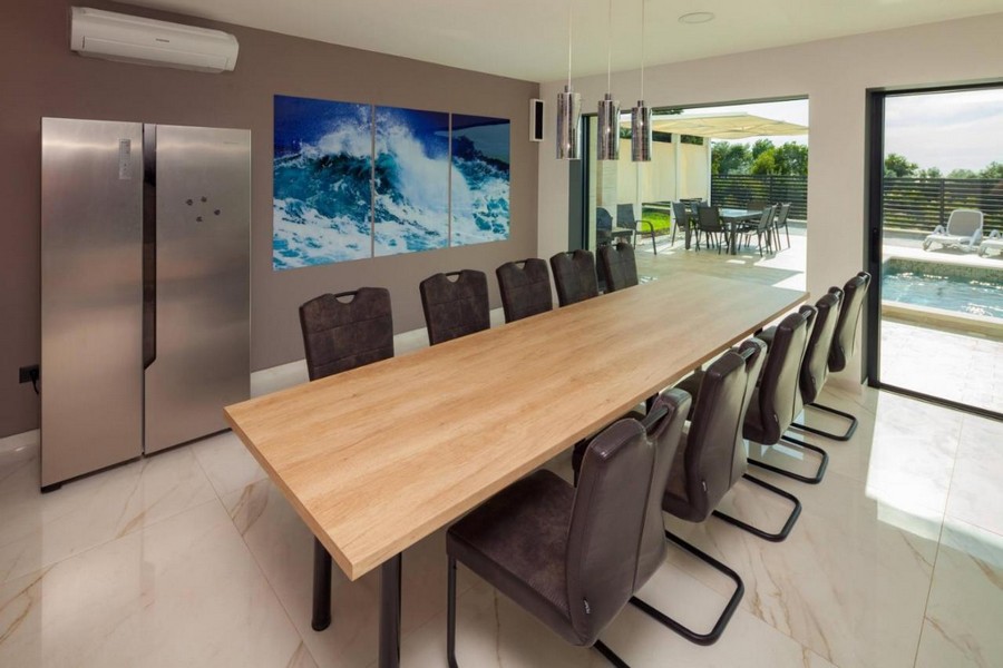 Matplats med stort träbord och tillgång till poolterrassen