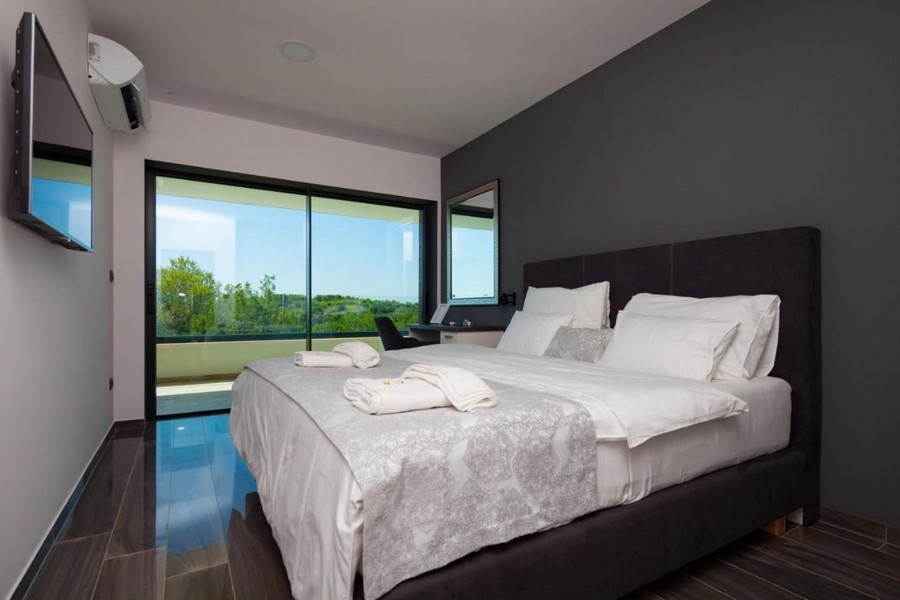 Elegant sovrum med dubbelsäng och utsikt över landskapet